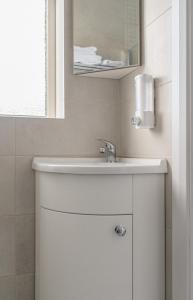 a bathroom with a white sink and a mirror at Newtown Cove Room 1 in Waterford