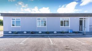 a white building with windows and a parking lot at Newtown Cove Room 1 in Waterford