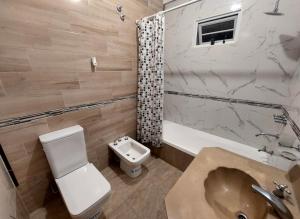 a bathroom with a sink and a toilet and a tub at Departamento Aires del Golf in Termas de Río Hondo +40 photos