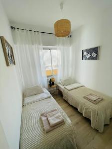 two beds in a room with white walls at Apartament Mariola in Calpe