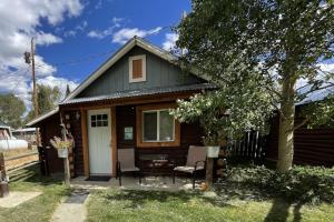 a small house with a porch and a chair at Stay Twin Lakes Cabin 4 in Twin Lakes