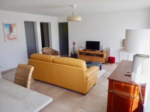 salon z żółtą kanapą i telewizorem w obiekcie Appartement en Provence-Lubéron - piscine et calme w mieście Volx