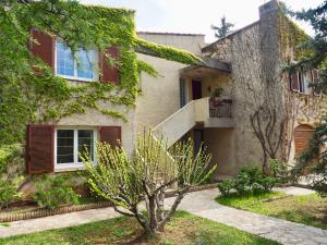 dom z drzewem przed nim w obiekcie Appartement en Provence-Lubéron - piscine et calme w mieście Volx