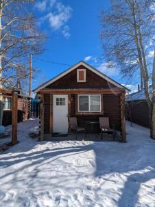 eine kleine Hütte mit zwei Stühlen im Schnee in der Unterkunft Stay Twin Lakes Cabin 3 in Twin Lakes