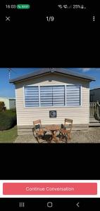 a picture of a house with two chairs and a table at Ocean Heights 5 star site NewQuay in Llanllwchaiarn