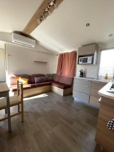a living room with a couch and a kitchen at RELAX FO70 in Fréjus