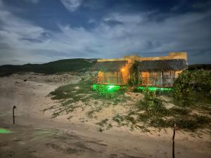 a house sitting on top of a beach at night at Bangalô Encantador Praia da Baleia in Itapipoca