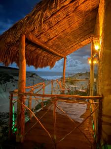 a straw hut on the beach at night at Bangalô Encantador Praia da Baleia in Itapipoca