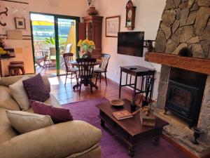 a living room with a couch and a fireplace at La Cuadra in Buenavista del Norte