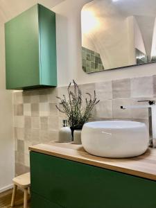 a bathroom with a white sink and green cabinets at Via Scale Apartments, Lake Como, Brienno in Brienno