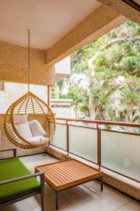 a porch with a swing and a chair on a balcony at Renovated 2BR with Balcony in Bauhaus *Beachfront* in Tel Aviv