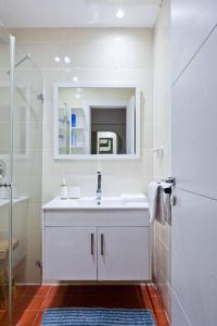 a white bathroom with a sink and a shower at Renovated 2BR with Balcony in Bauhaus *Beachfront* in Tel Aviv +43 photos