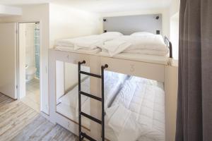 a bedroom with a bunk bed with white sheets at Oberstdorf Hostel in Oberstdorf