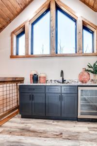 a kitchen with blue cabinets and windows at Piney Estate Hot Tub Game Theater Room in Gatlinburg