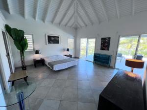 Schlafzimmer mit einem Bett und einem Glastisch in der Unterkunft Villa Taïana in Saint Martin