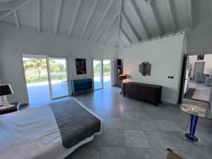 a bedroom with a large bed in a room with windows at Villa Taïana in Saint Martin