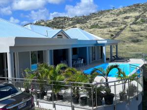 a house with a swimming pool and a hill at Villa Taïana in Saint Martin