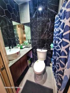 La salle de bains est pourvue de toilettes et d'un lavabo. dans l'établissement Luxurious Romantic Getaway in a stylish Condo, à Tagaytay