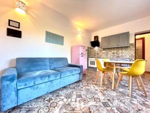 バリ・サルドにあるLe Corti Sarde Countrysideのリビングルーム(青いソファ、テーブル、椅子付)
