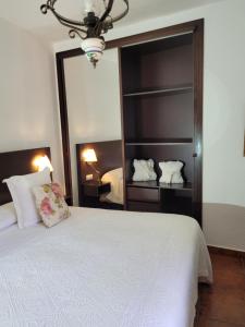 a bedroom with a white bed and a large mirror at La Cuadra in Buenavista del Norte