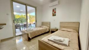 1 Schlafzimmer mit 2 Betten und einem Balkon mit einem Tisch in der Unterkunft Villa Georgina & Villa Marianda Coral Bay in Coral Bay + 30 Fotos