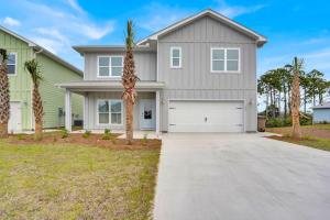 una casa con una palmera frente a una entrada en The Cozy Clam, en Cape San Blas