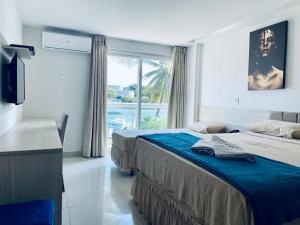 a hotel room with two beds and a window at Ibiza Barra Hotel in Rio de Janeiro
