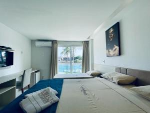 1 dormitorio con 2 camas y ventana grande en Ibiza Barra Hotel, en Río de Janeiro