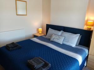 a bedroom with a blue bed with towels on it at Copper Mine Cottage in Llandudno