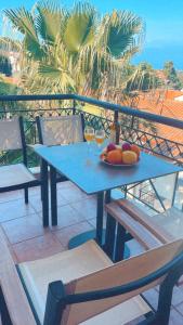 a blue table with a bowl of fruit on a balcony at Klapidis apartments in Kriopigi