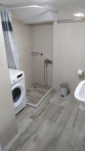 a bathroom with a shower and a washing machine at Enastron Cozy & Quiet Apartment in Heraklio