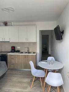a kitchen with a table and two chairs and a table at Enastron Cozy & Quiet Apartment in Heraklio