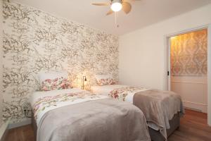 2 bedden in een kamer met bloemenbehang bij CASASdeCASPER - Apartment Alkmaar in Alkmaar