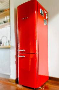- un réfrigérateur rouge avec des aimants dans la cuisine dans l'établissement Maresias Beach Cottage, à São Sebastião