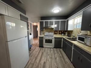 Una cocina con electrodomésticos blancos y suelo de madera. en Beach Break House by the Surf, en Daytona Beach 17 fotos más