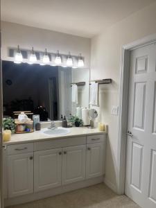 uma casa de banho com um lavatório e um espelho grande em Exclusive Private Room in the Shared Apartment by the Ocean em Los Angeles