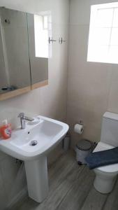 a white bathroom with a sink and a toilet at Iliaktis Cozy & Quiet Apartment in Heraklio Town