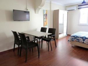 - une salle à manger avec une table, des chaises et un lit dans l'établissement Istanberry - Royal Apartments, à Istanbul
