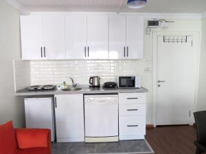 eine Küche mit weißen Schränken und einer Mikrowelle in der Unterkunft Istanberry - Royal Apartments in Istanbul