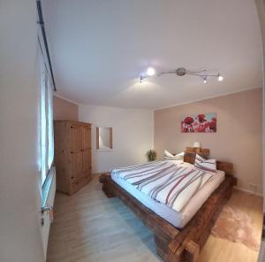 1 dormitorio con 1 cama grande con marco de madera en Ferienwohnung Döhlerwald en Klingenthal
