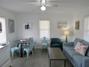 a living room with a couch and a table and chairs at Saltaire Cottages in Kitty Hawk Beach