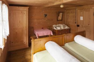 a room with two beds in a wooden room at Hotel Waldrand in Kiental