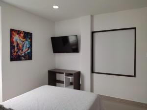 una camera con letto e TV a schermo piatto di Habitación Amoblada Tipo Hotel a Tuluá