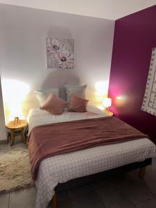 una camera da letto con un grande letto con pareti viola di Gîte la grande racinaie a Cré-sur-Loir