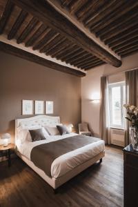 una camera con un grande letto e un pavimento in legno di Villa Adelaide Relais & Wine a Calamandrana