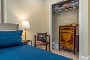 ダフネにあるBlue Albatross - Daphneのベッドと椅子とドレッサーのある寝室