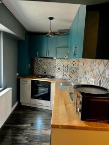 a kitchen with blue cabinets and a counter top at Studio G1 in Moineşti
