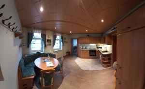 ein Wohnzimmer und eine Küche mit einem Tisch und einem Sofa in der Unterkunft Ferienwohnung Döhlerwald in Klingenthal