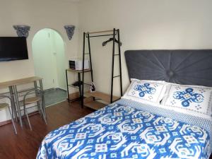 - une chambre avec un lit bleu et blanc et un bureau dans l'établissement Istanberry - Royal Apartments, à Istanbul