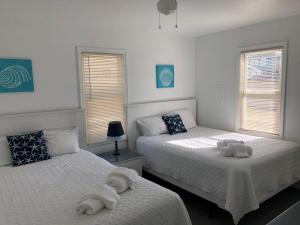a bedroom with two beds with towels on them at Saltaire Cottages in Kitty Hawk Beach +207 photos